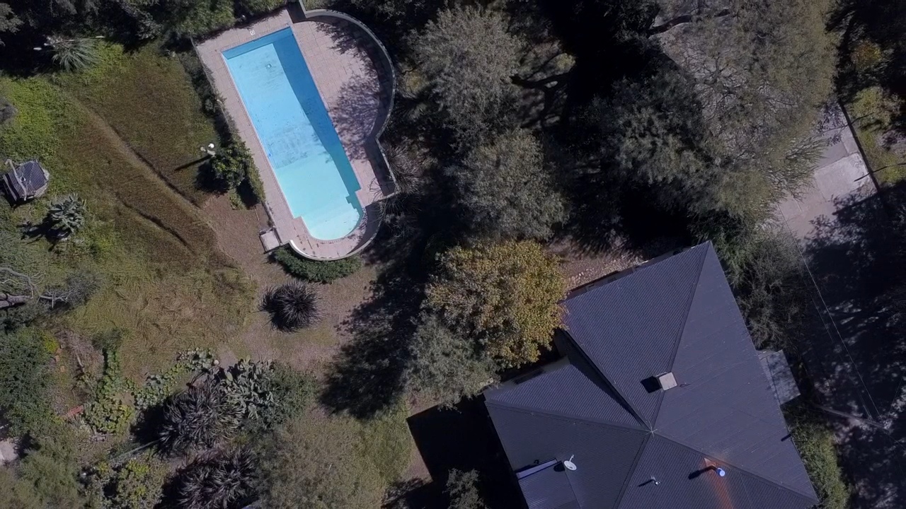 Vista aérea del terreno con pileta y casas vecinas